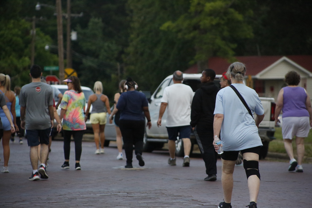 A man standing next to some ropes and a horse.