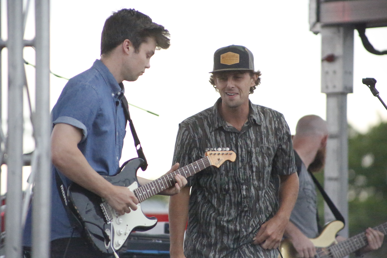 A man standing next to some ropes and a horse.