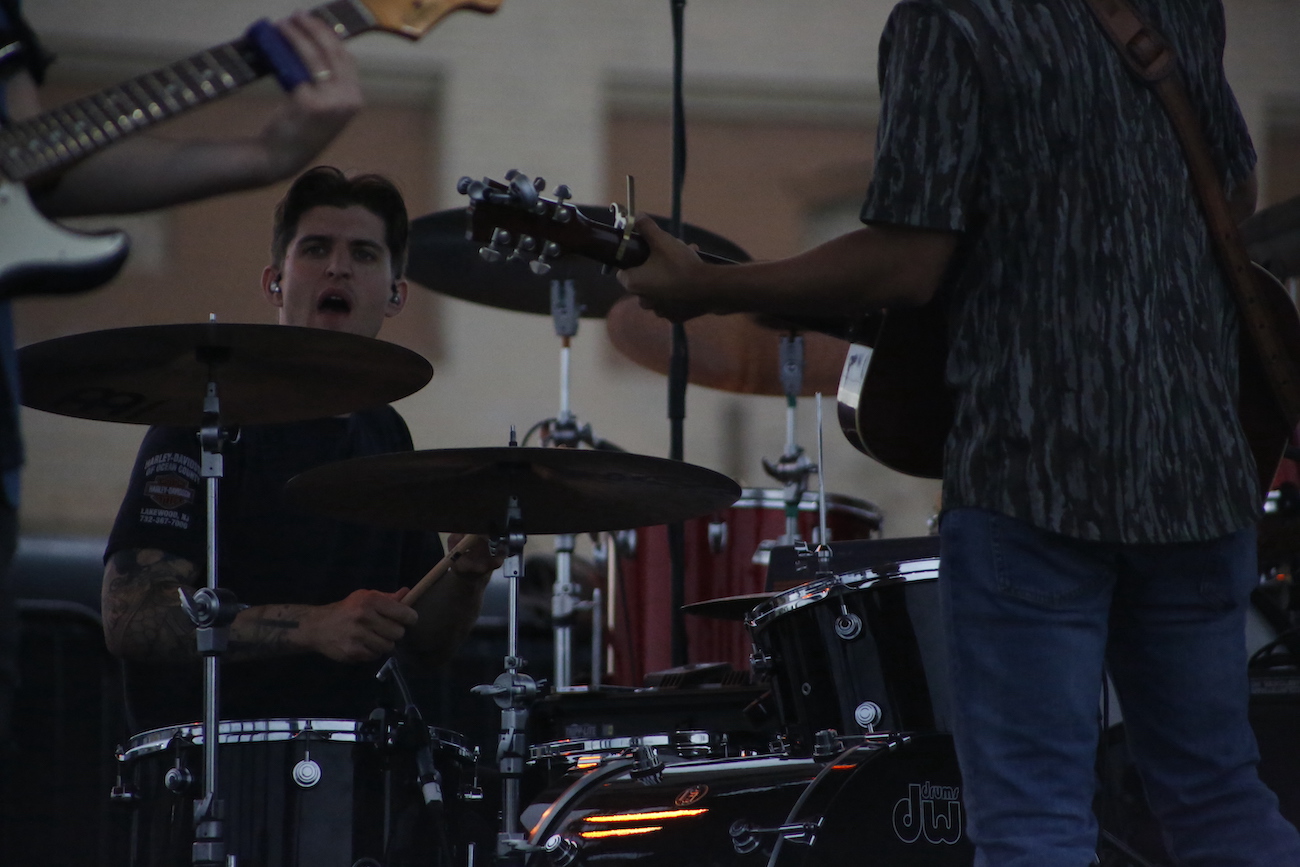 A man standing next to some ropes and a horse.