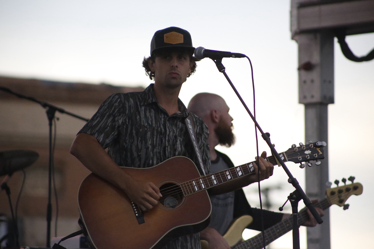 A man standing next to some ropes and a horse.