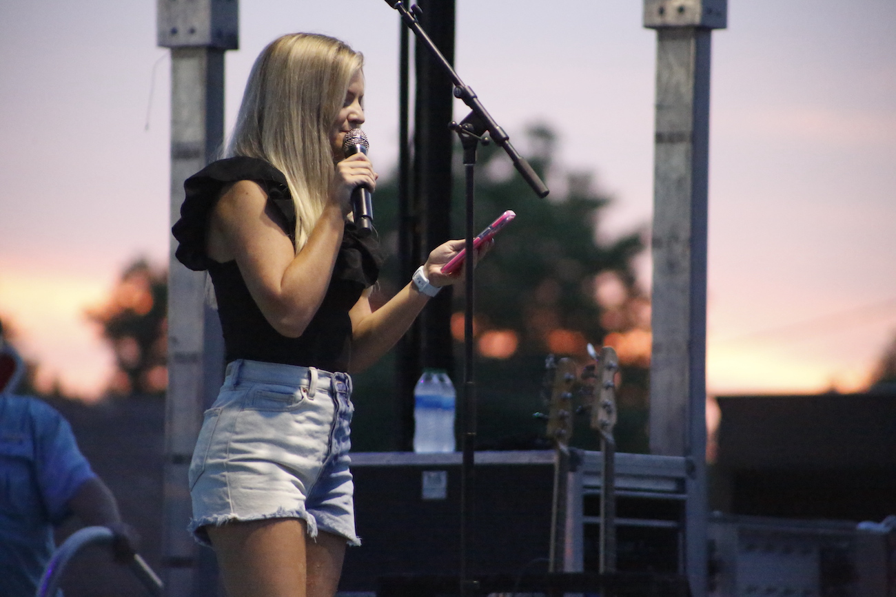 A man standing next to some ropes and a horse.