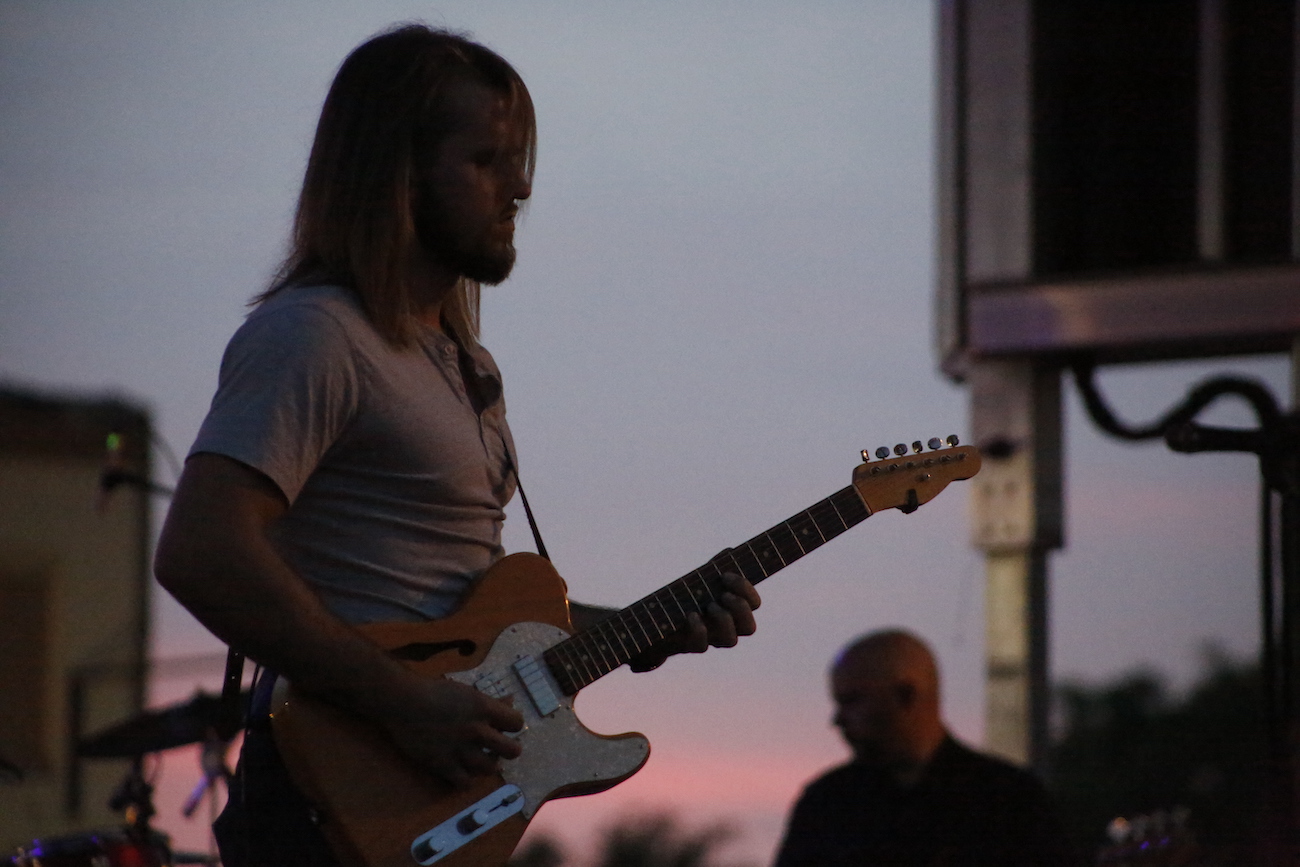 A man standing next to some ropes and a horse.