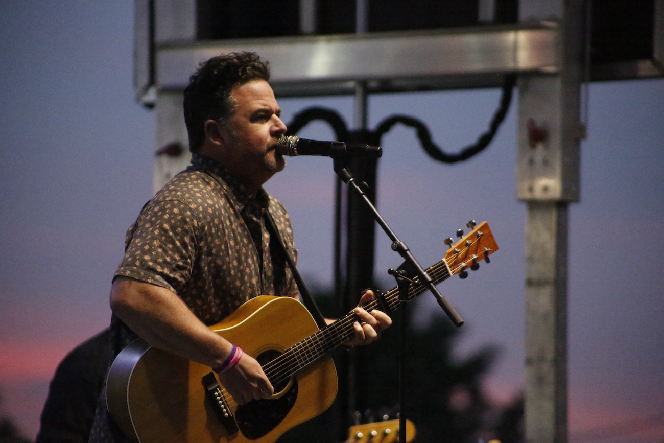 A man standing next to some ropes and a horse.