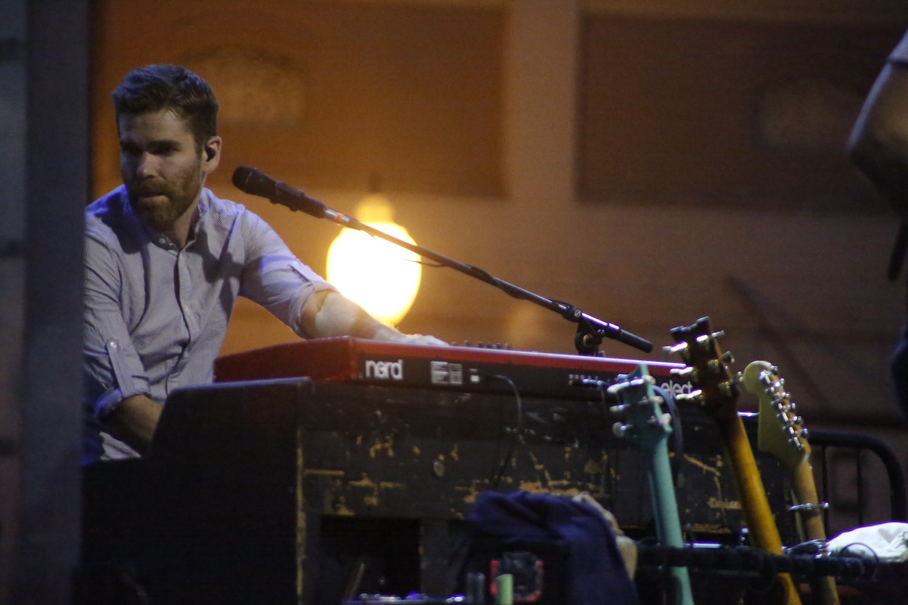 A man standing next to some ropes and a horse.