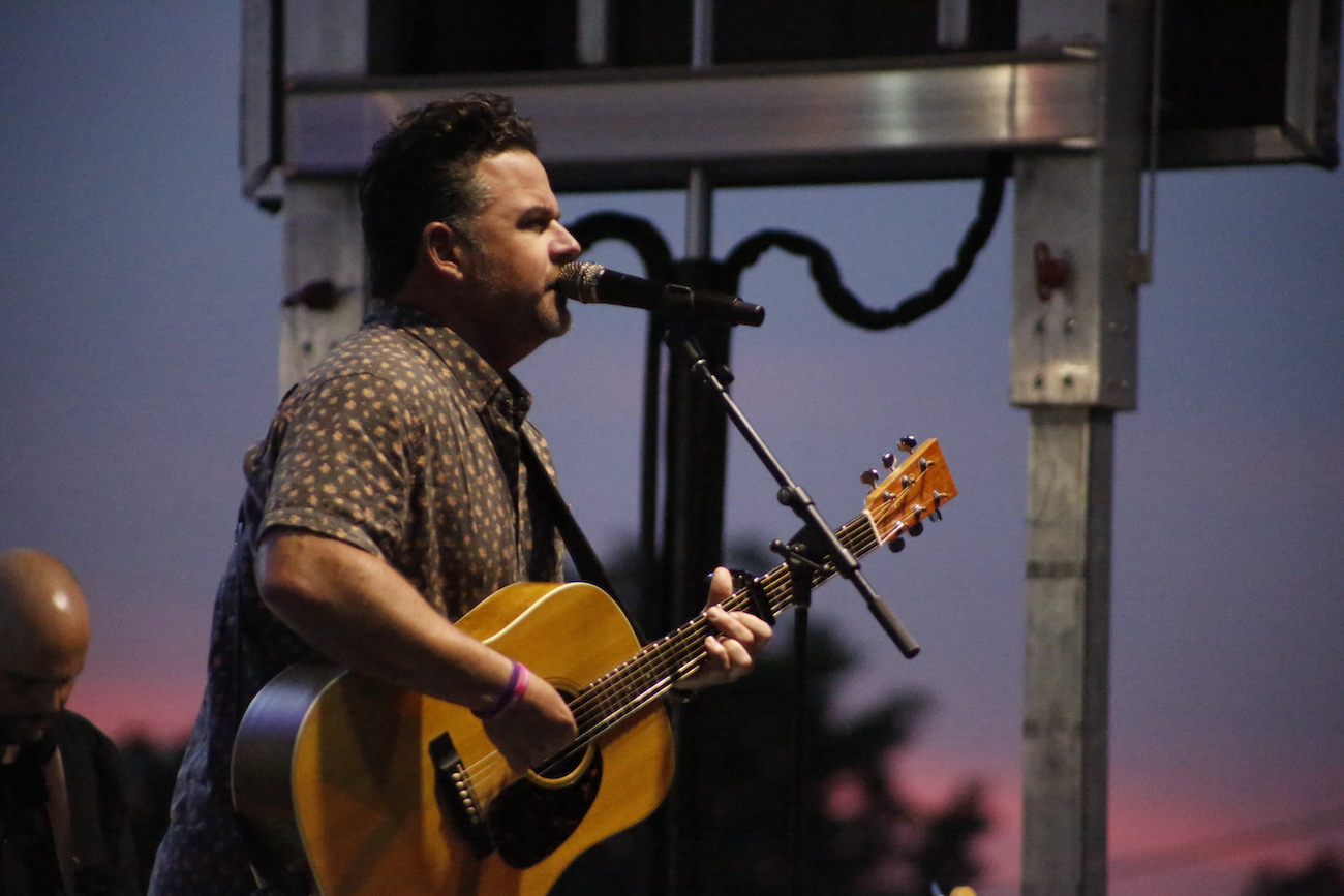 A man standing next to some ropes and a horse.