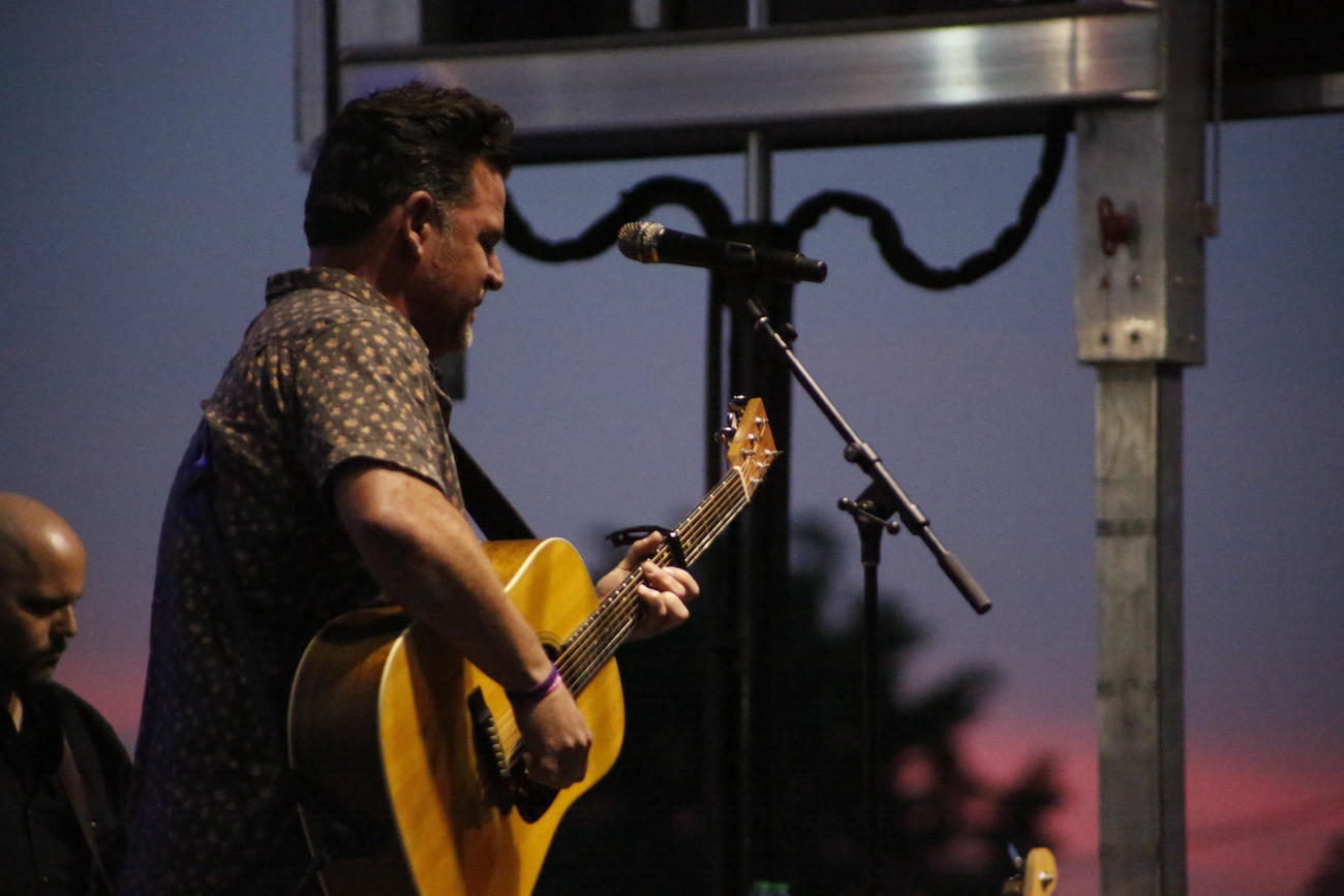 A man standing next to some ropes and a horse.