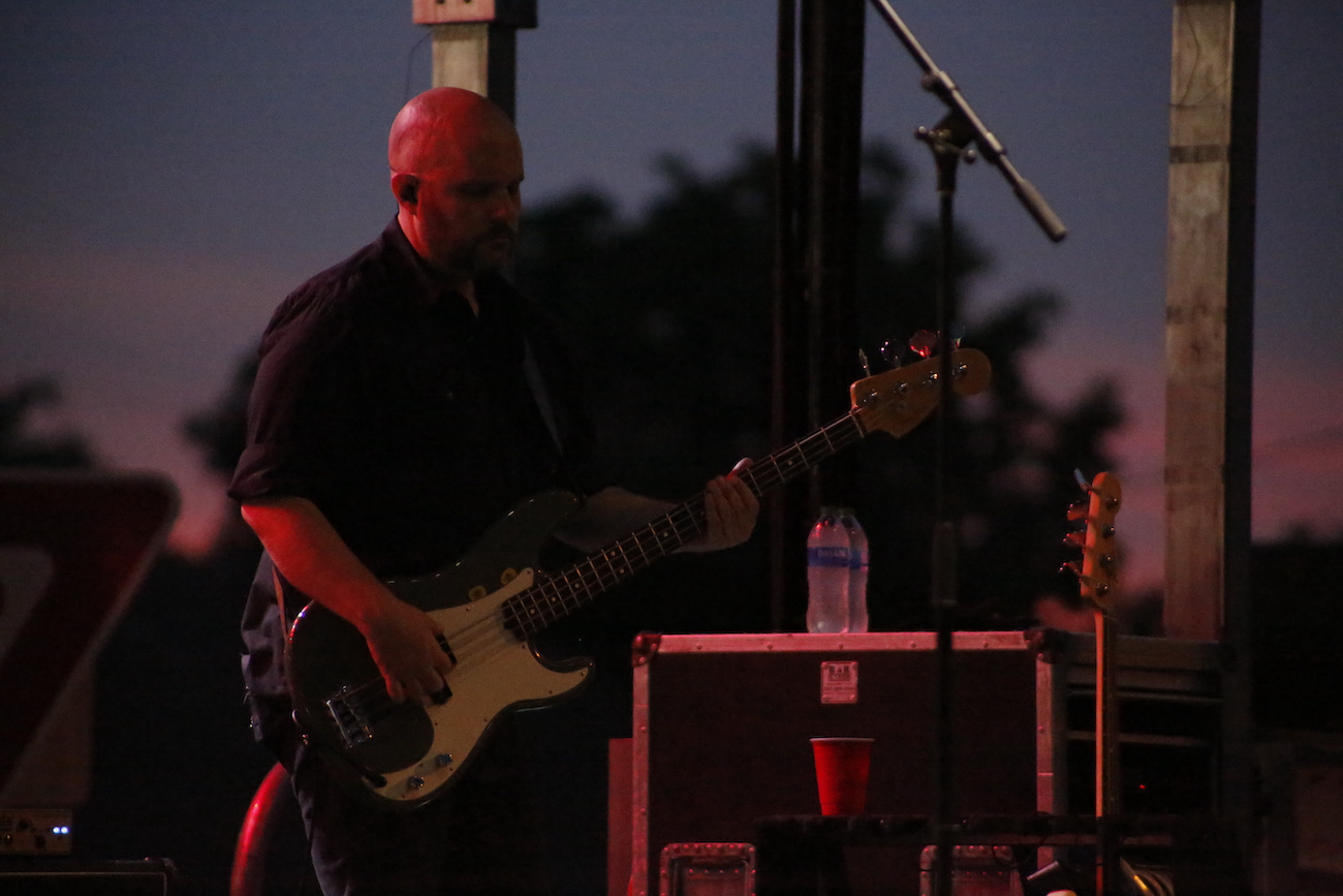 A man standing next to some ropes and a horse.