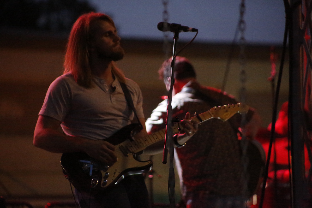 A man standing next to some ropes and a horse.