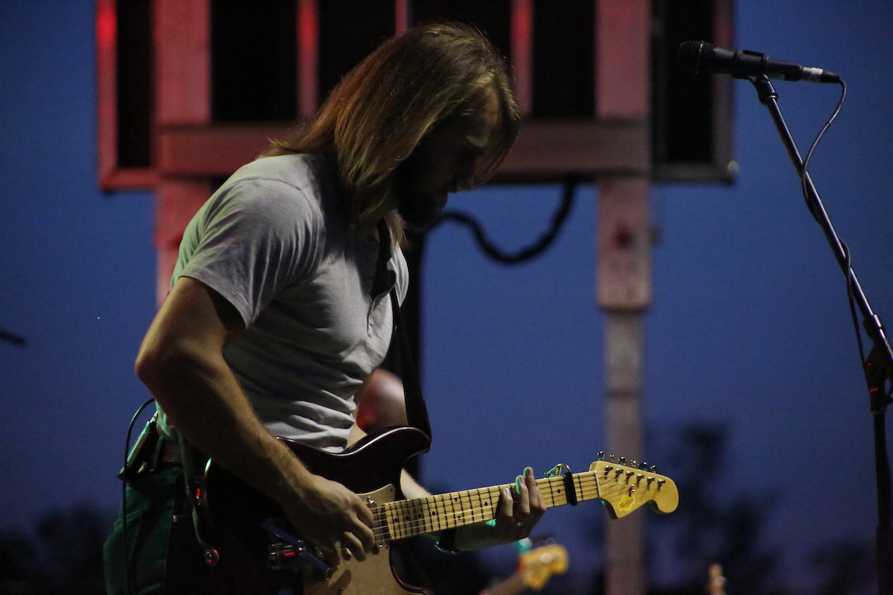 A man standing next to some ropes and a horse.