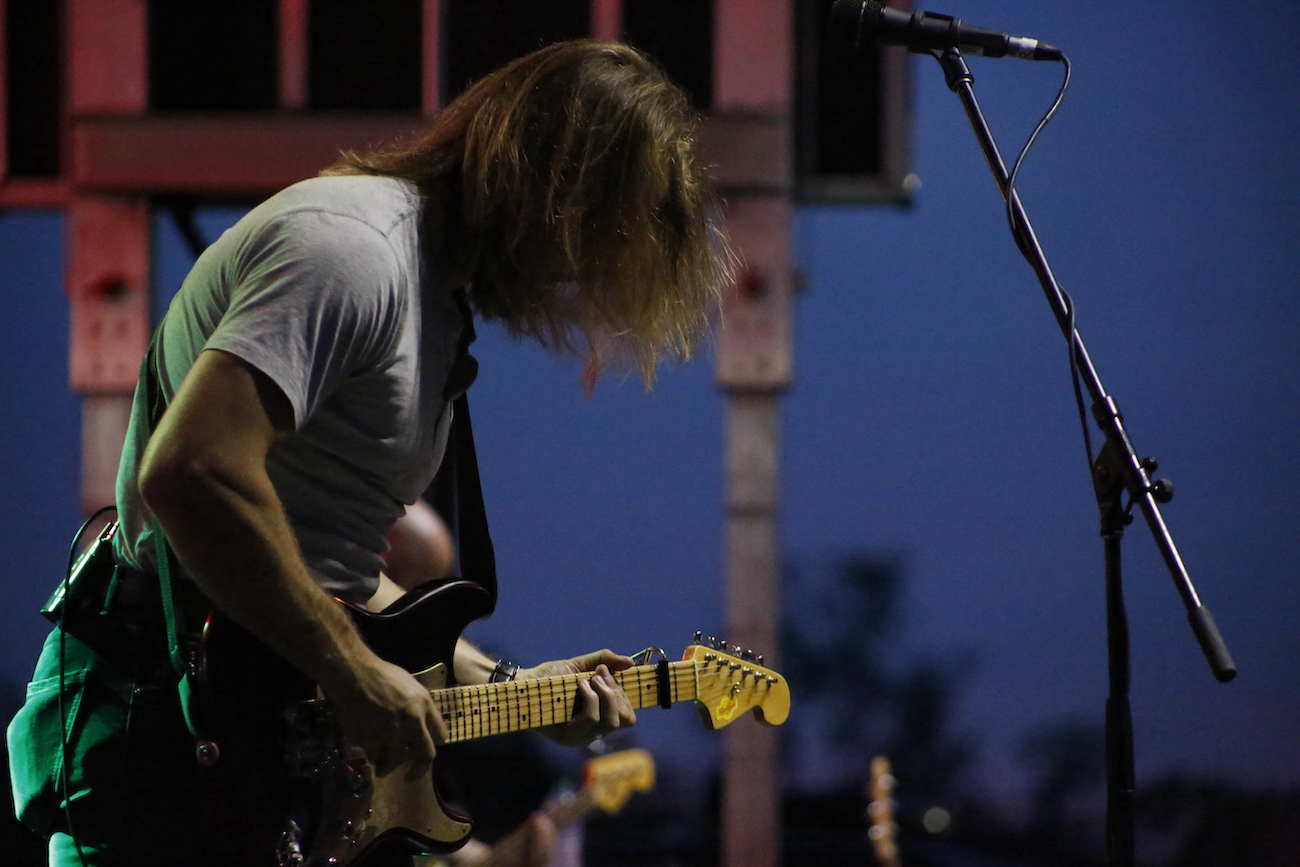 A man standing next to some ropes and a horse.