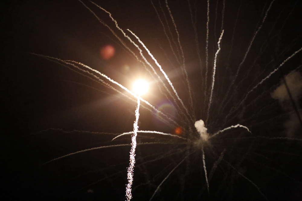 A man standing next to some ropes and a horse.