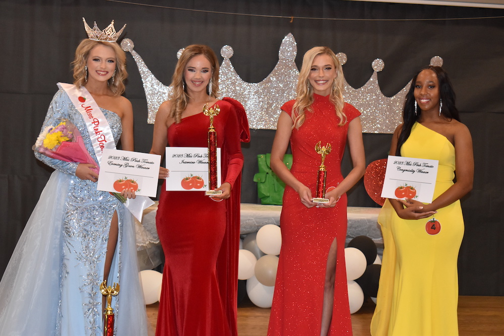 A group of women in formal wear holding awards.