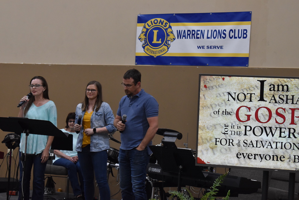 A group of people standing in front of a banner.