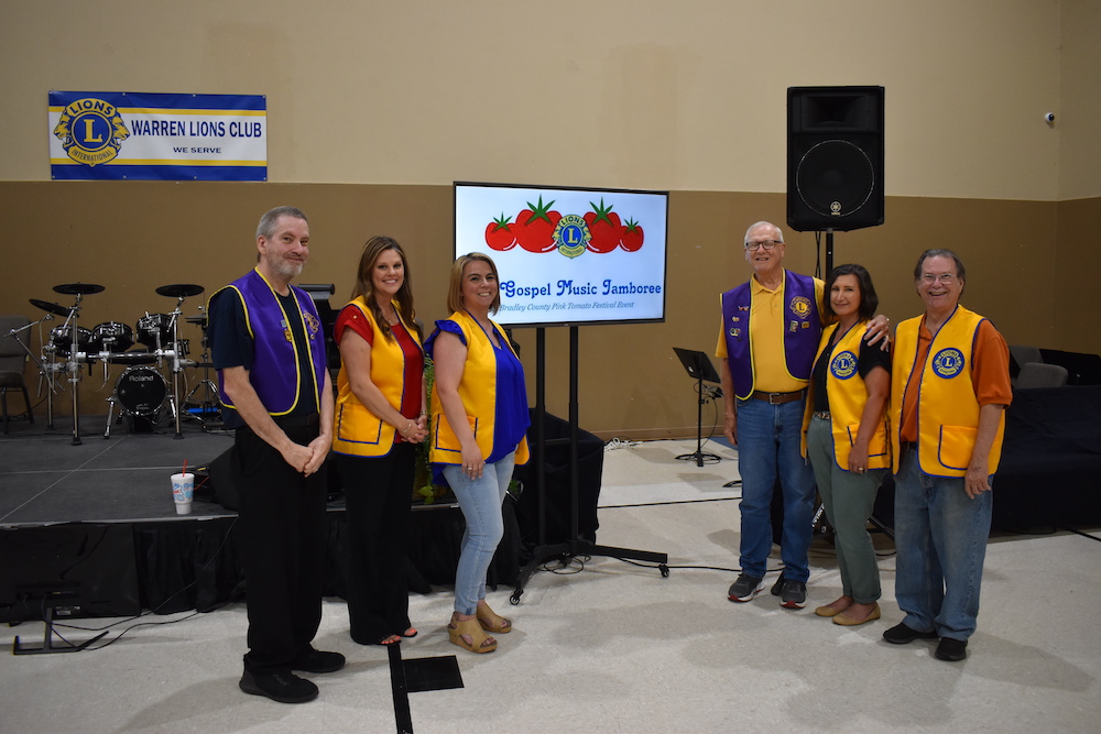 A group of people standing in front of a projector screen.