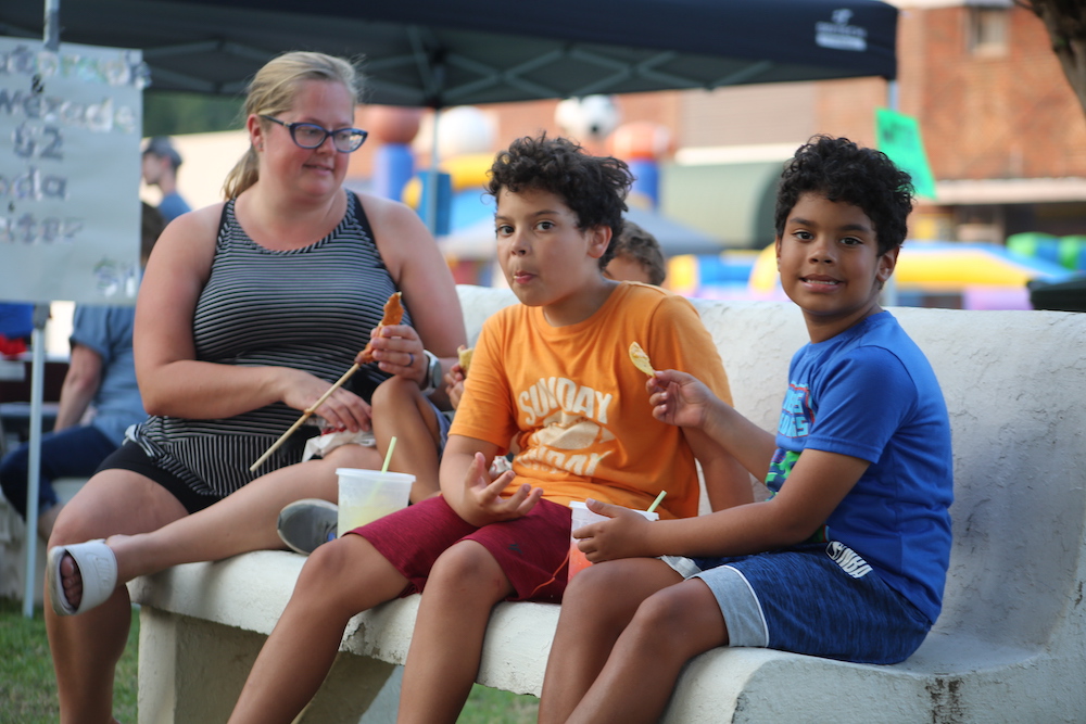 A group of people sitting on top of a white couch.