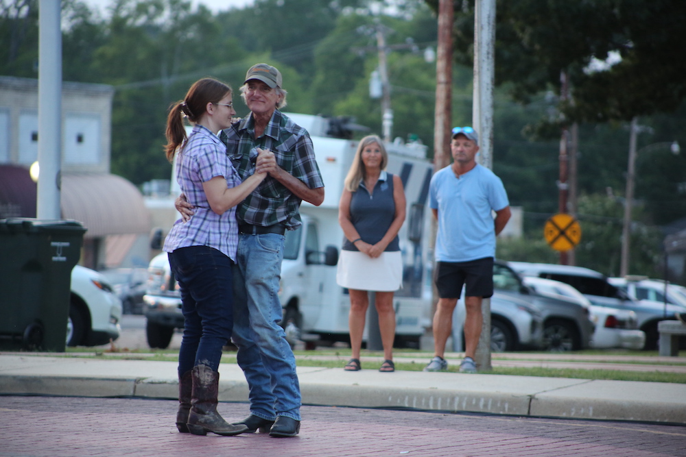 A man and woman dancing on the sidewalk.