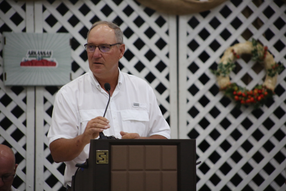 A man standing at a podium with a microphone.
