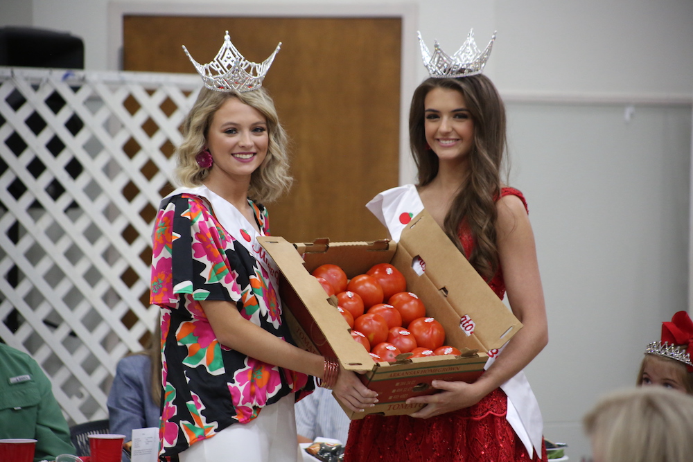 Two women holding a box of tomatoes