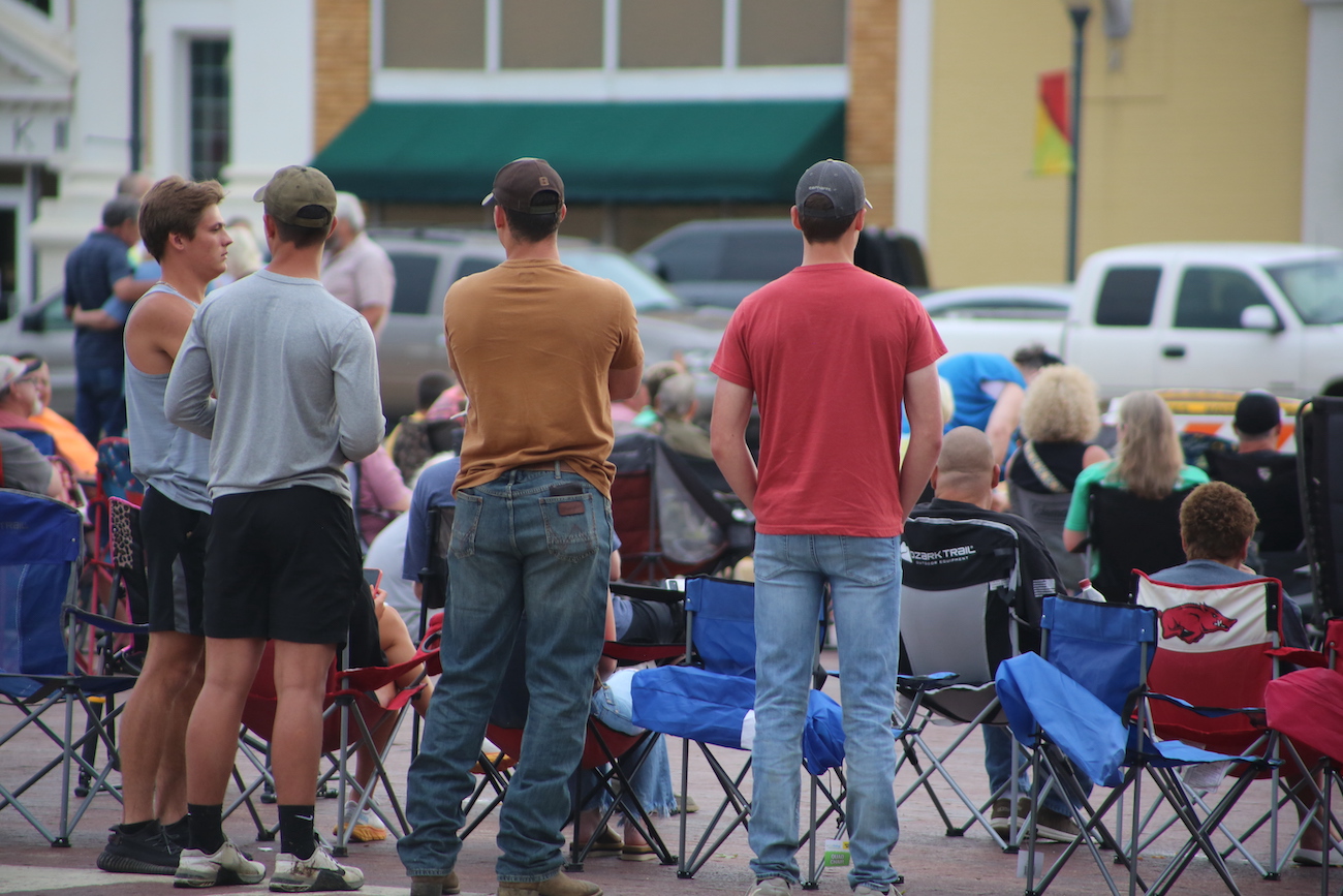 A group of people standing around in chairs.