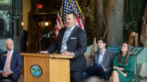 A man in suit and tie standing at a podium.
