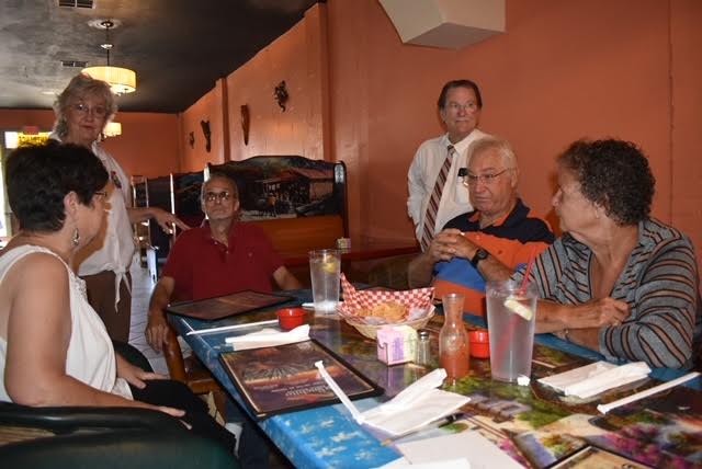 A group of people sitting at a table with drinks.