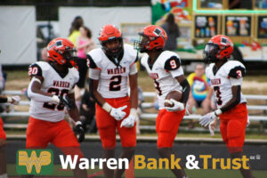 A group of football players standing on top of a field.