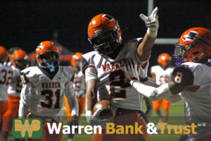 A football player is holding his hands up.