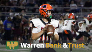 A football player holding a ball and wearing an orange helmet.