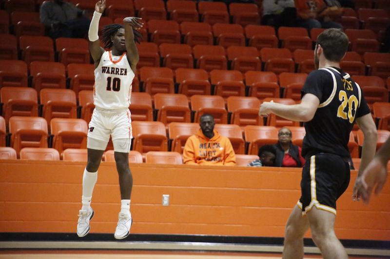 A man in white shorts and black shirt playing basketball.