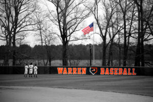A baseball team standing on the field with their uniforms.