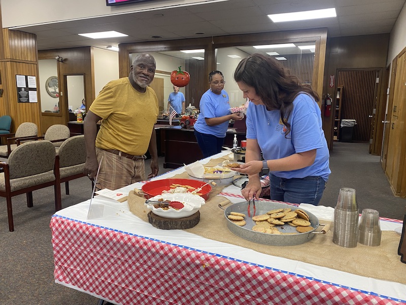 A woman is cutting food at an event.