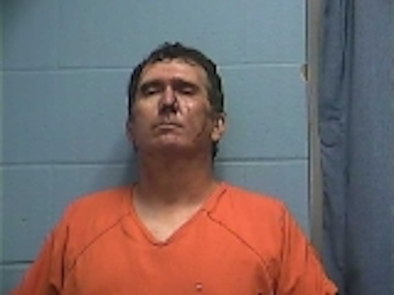A man in an orange shirt is standing up.