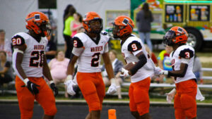 Two football players are talking to each other.