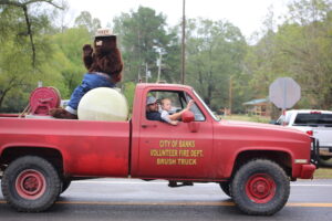 A red truck with people in the back of it.