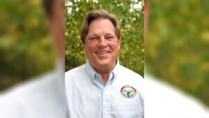 A man with long hair and a white shirt.