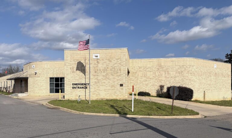 A building with an american flag flying in the background.