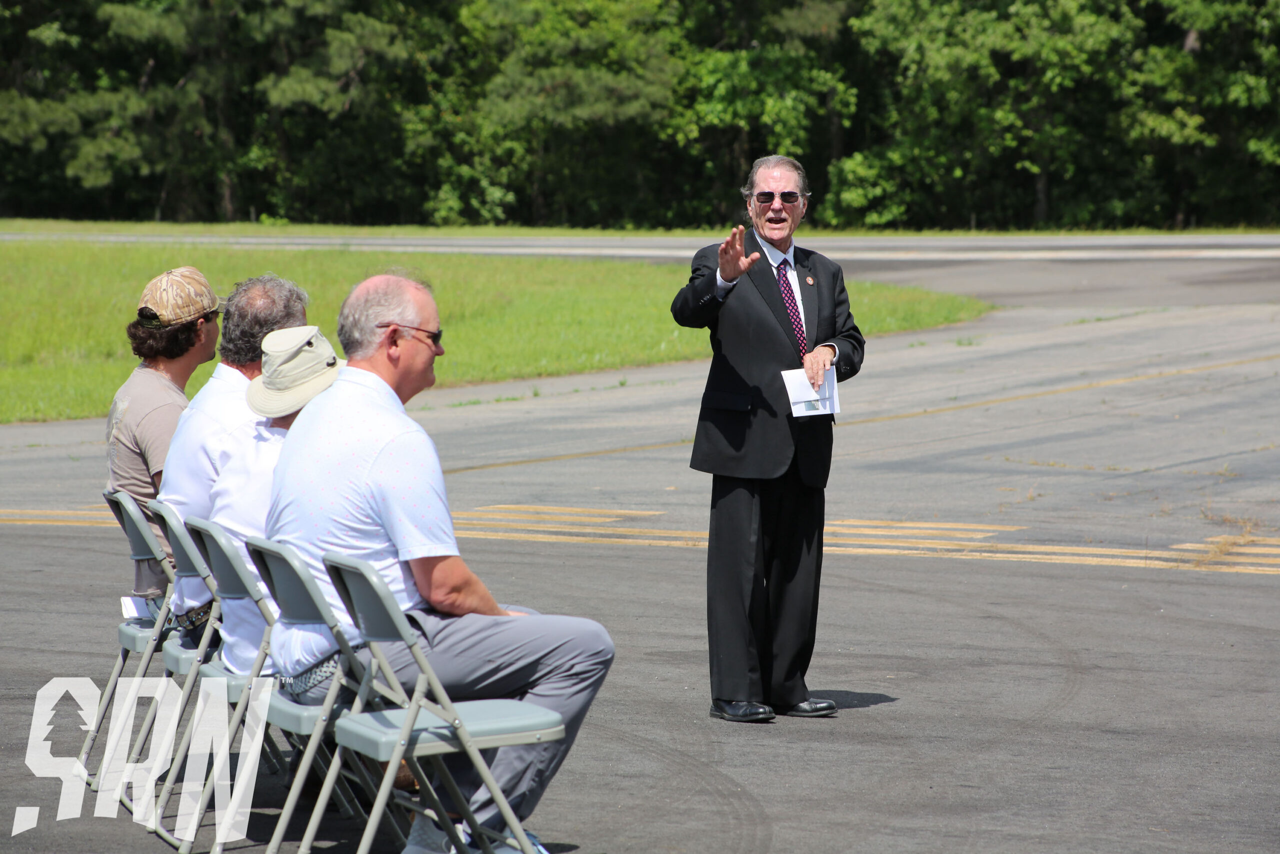 A man in suit and tie standing on the side of a road.