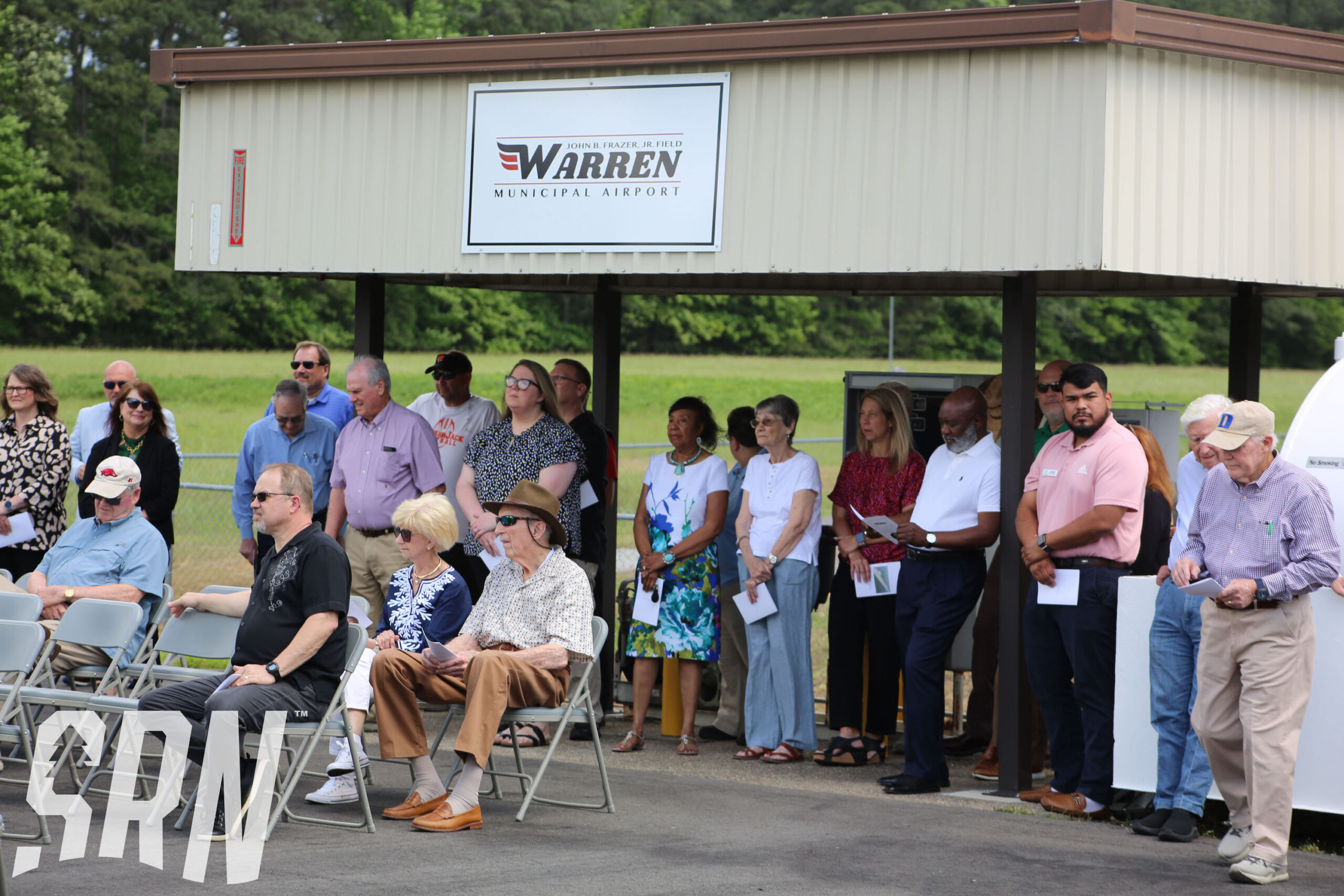 A group of people standing around in chairs.