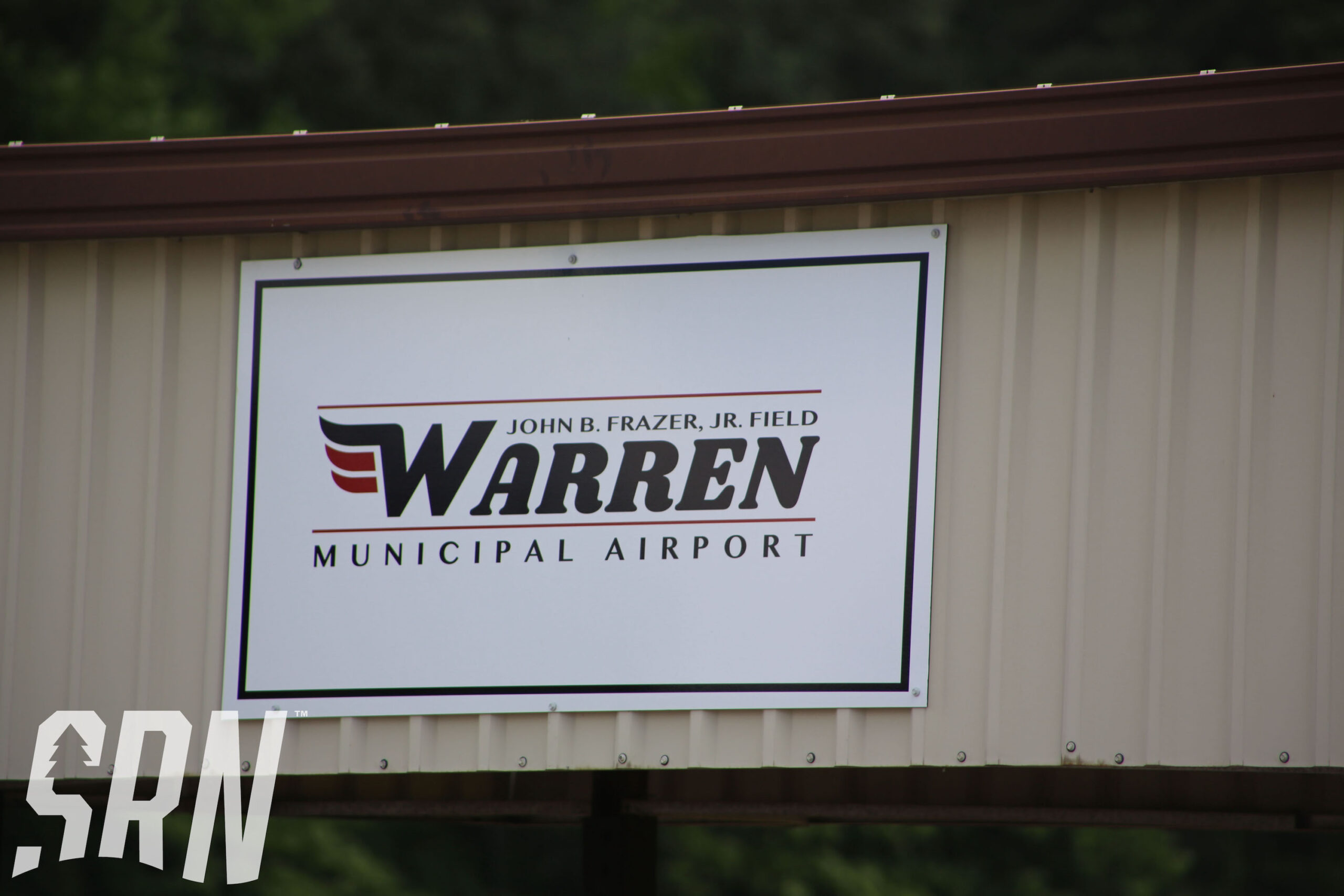 A sign for warren municipal airport on the side of a building.