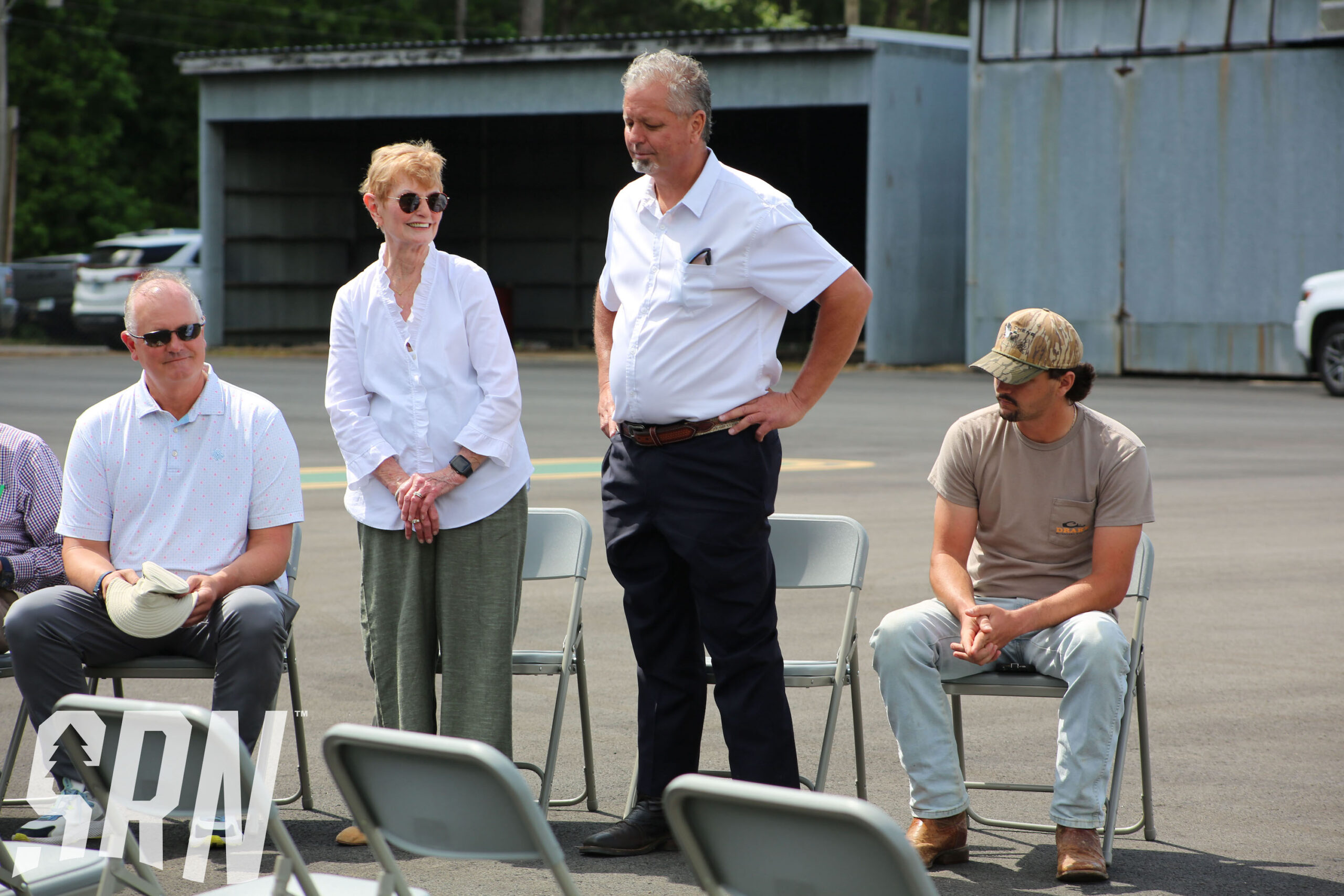 A group of people sitting in chairs on the ground.
