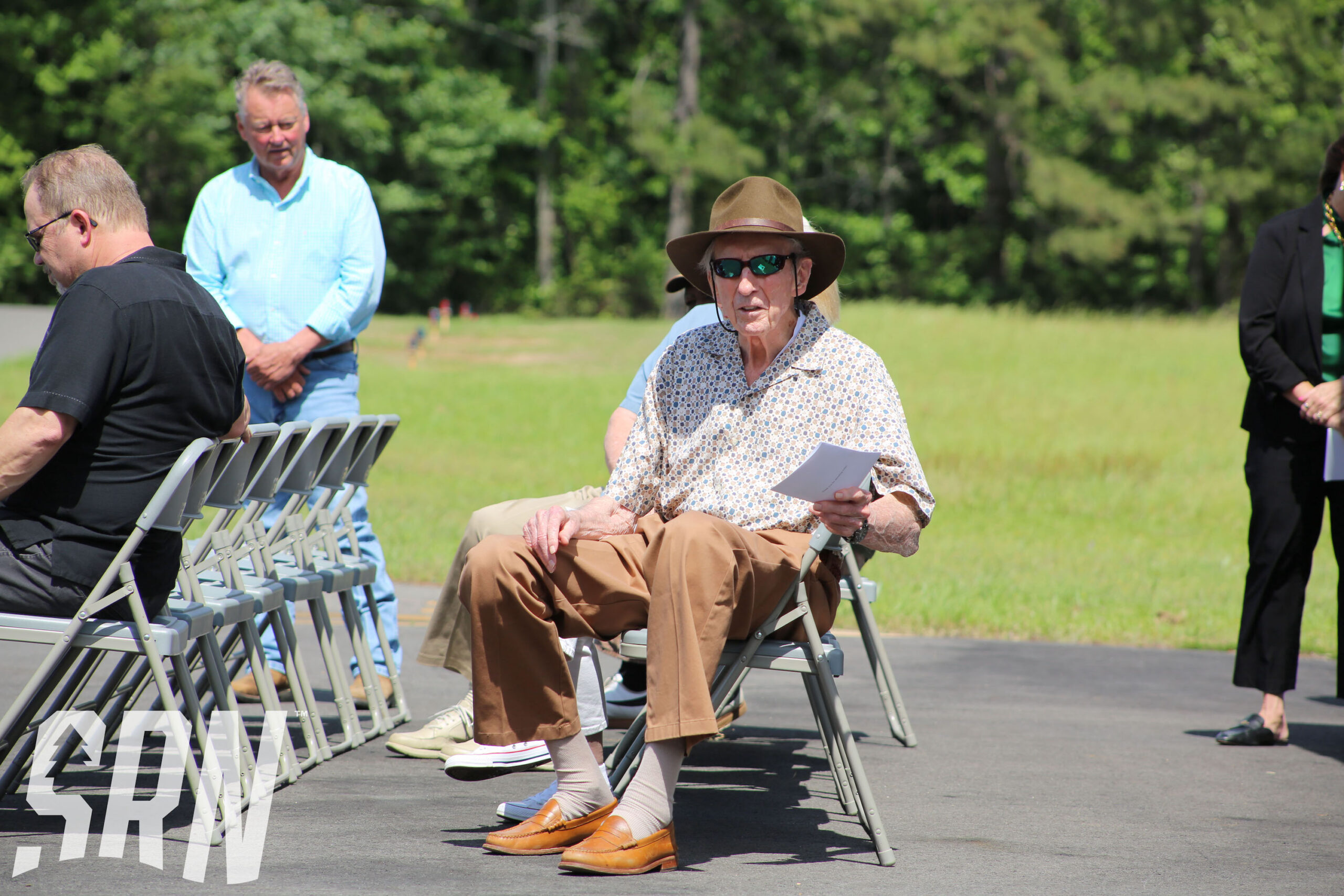 A man sitting in an outdoor chair on the ground.