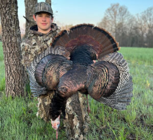 A man holding a turkey in his hand.