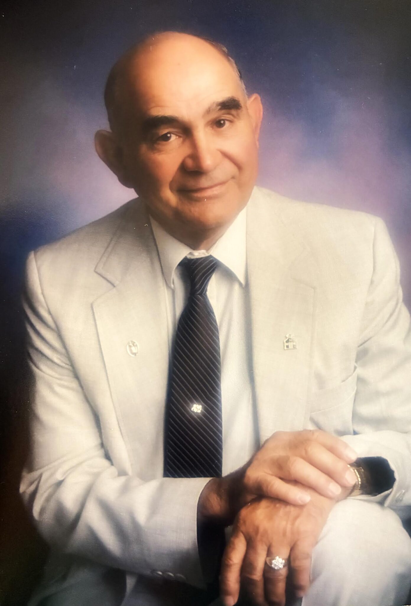 A man in a suit and tie holding a watch.