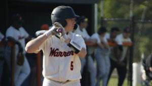 A baseball player is holding his bat ready to swing.