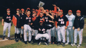 A group of baseball players holding up their trophy.