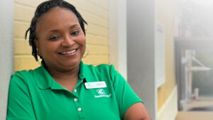 A woman in green shirt smiling for the camera.