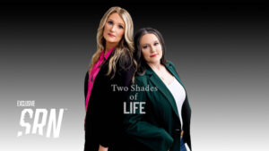 Two women in suits posing for a picture.