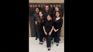 A group of people standing in front of a wall.