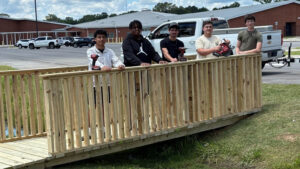 Four young men are standing on a bridge.