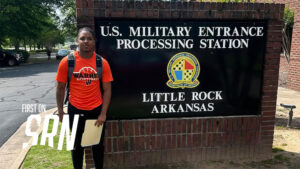 A person standing in front of a sign.
